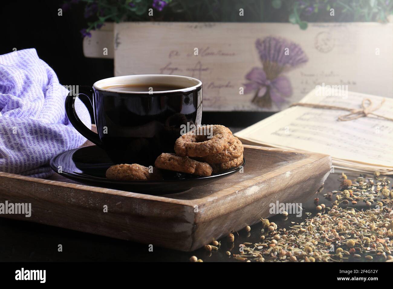 Una tazza di caffè caldo al mattino con luce solare e un sacco di fiori. Foto Stock