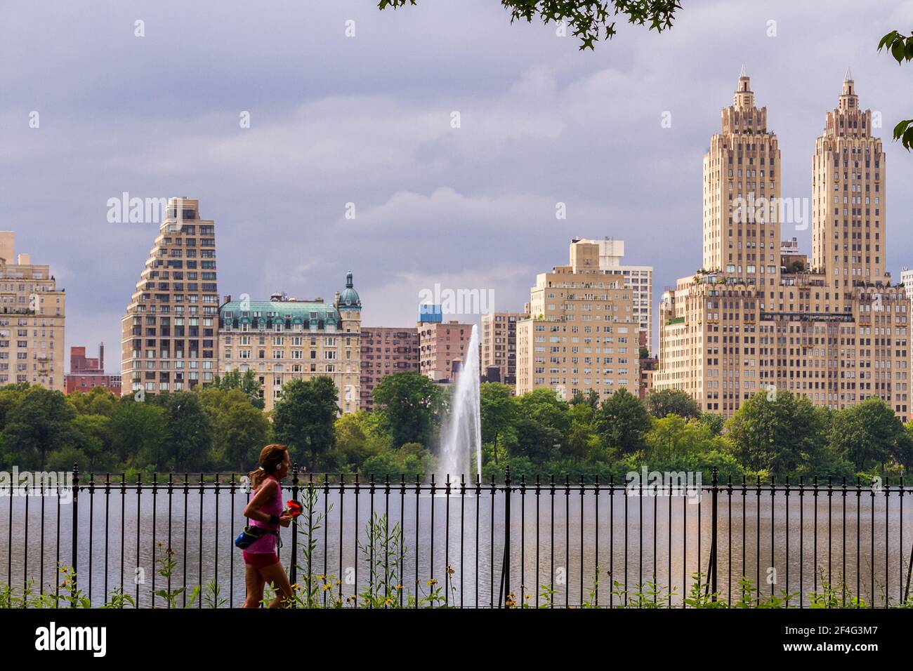 Giovane donna che fa jogging presso il bacino idrico Jacqueline Kennedy Onassis Central Park Foto Stock