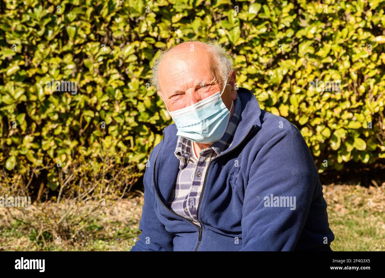 Ritratto dell'uomo anziano con maschera medica protettiva da pandemia di coronavirus. Concetto del pericolo del coronavirus per gli anziani. Foto Stock