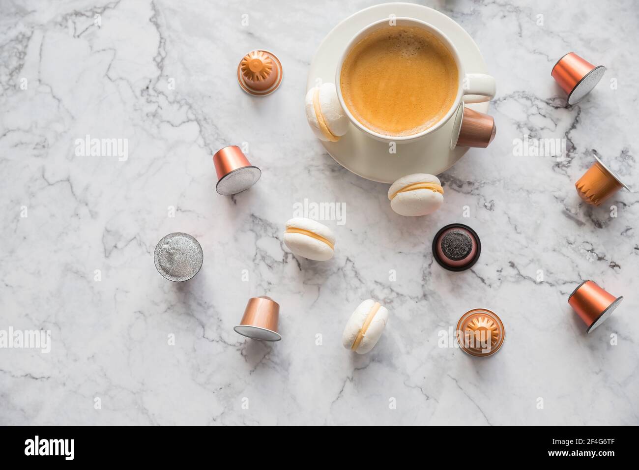 Tazza di caffè espresso, caffè nero servito con cialde e capsule su tavola di marmo. Raccolta di capsule di caffè espresso. Caffeina, bevande calde e oggetti Foto Stock