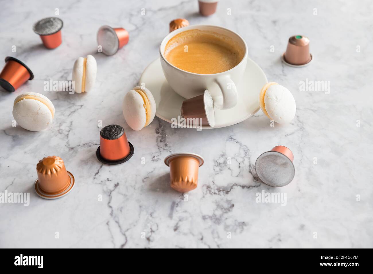 Tazza di caffè espresso, caffè nero servito con cialde e capsule su tavola di marmo. Raccolta di capsule di caffè espresso. Caffeina, bevande calde e oggetti Foto Stock