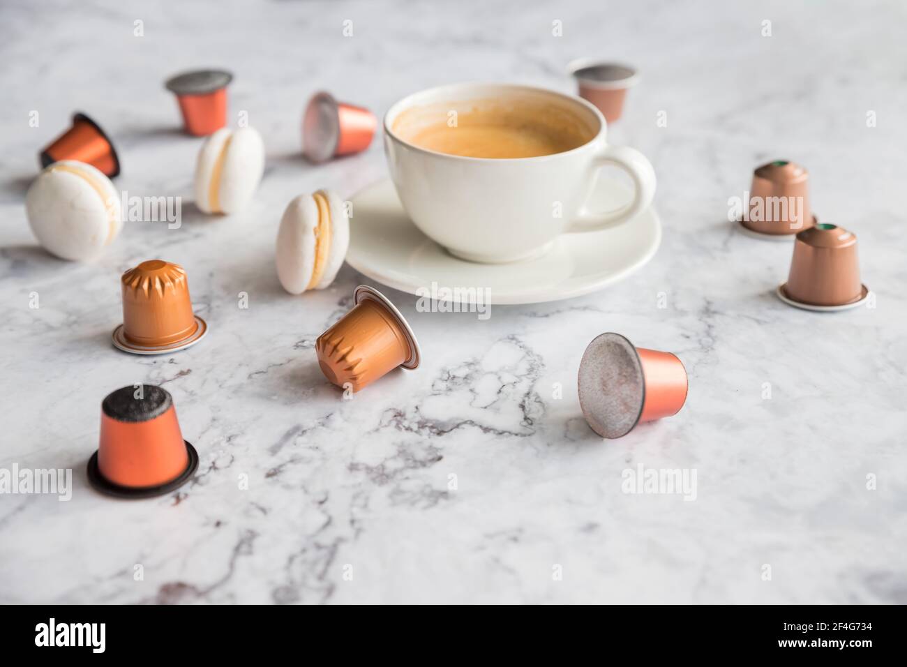 Tazza di caffè espresso, caffè nero servito con cialde e capsule su tavola di marmo. Raccolta di capsule di caffè espresso. Caffeina, bevande calde e oggetti Foto Stock