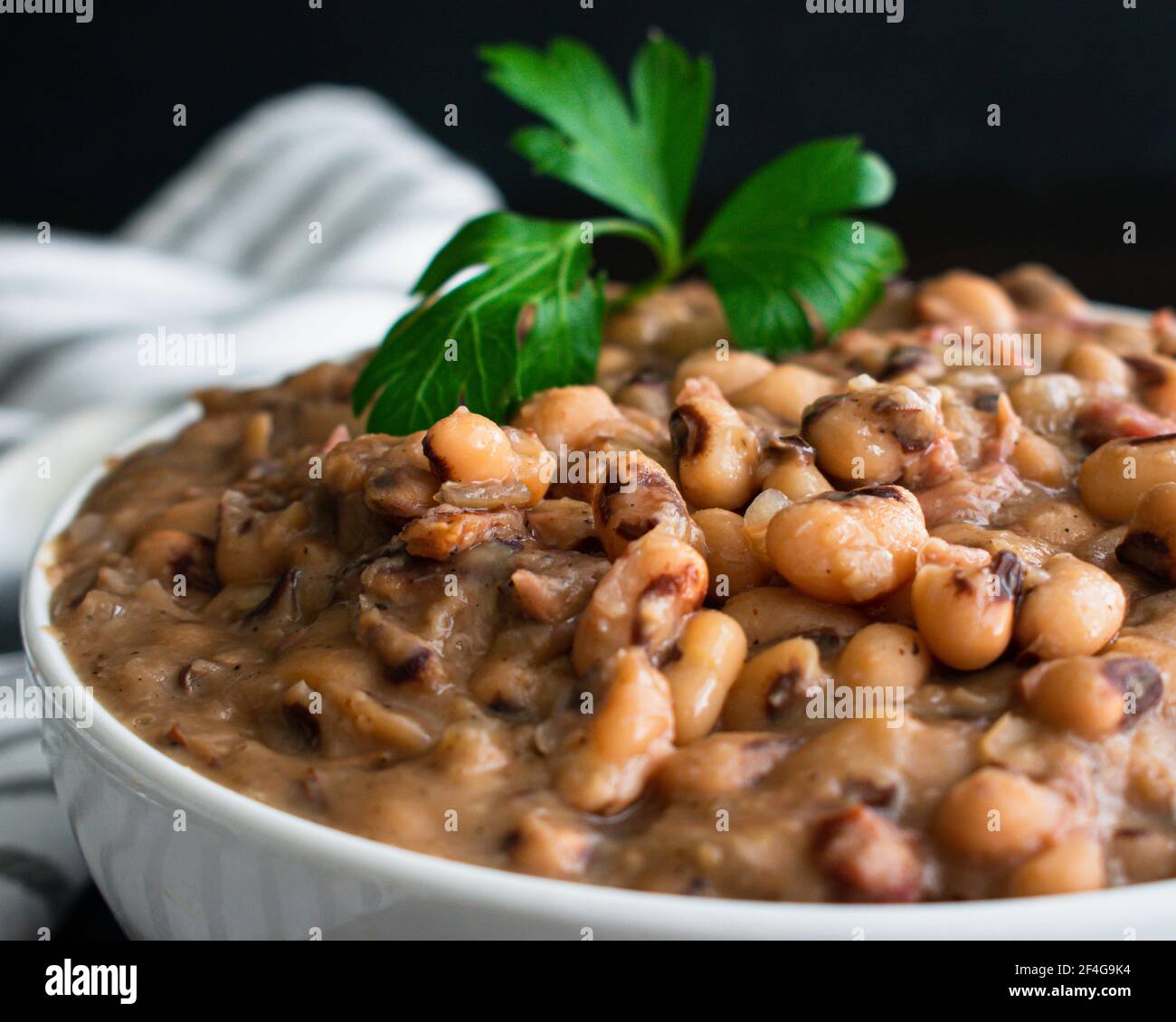 Southern Style Black-Eyed Peas: Vista closeup di una ciotola di cowpeas cotti e prosciutto affumicato hocks Foto Stock