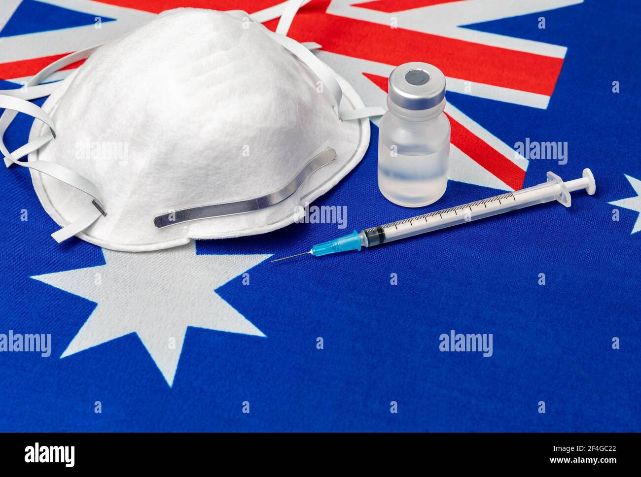 Flag Australia, maschera facciale N95, siringa per ago e flaconcino. Concetto di distribuzione del vaccino del coronavirus Covid-19, carenza di approvvigionamento e crisi sanitaria Foto Stock
