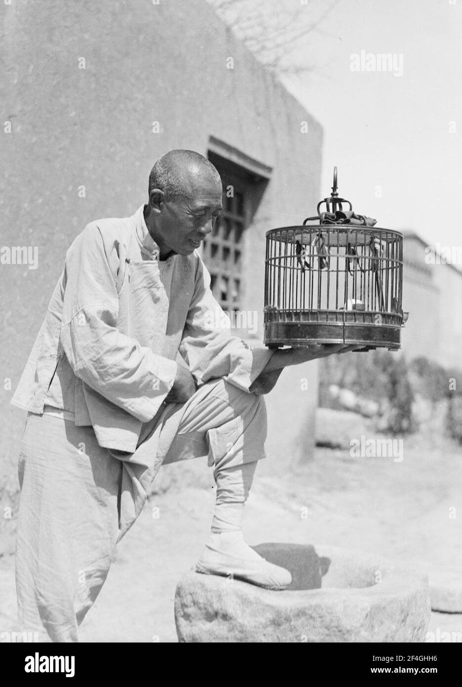 Uomo con gabbia di uccelli, Cina, Pechino (Cina), 1919. Dalla collezione di fotografie di Sidney D. Gamble. () Foto Stock