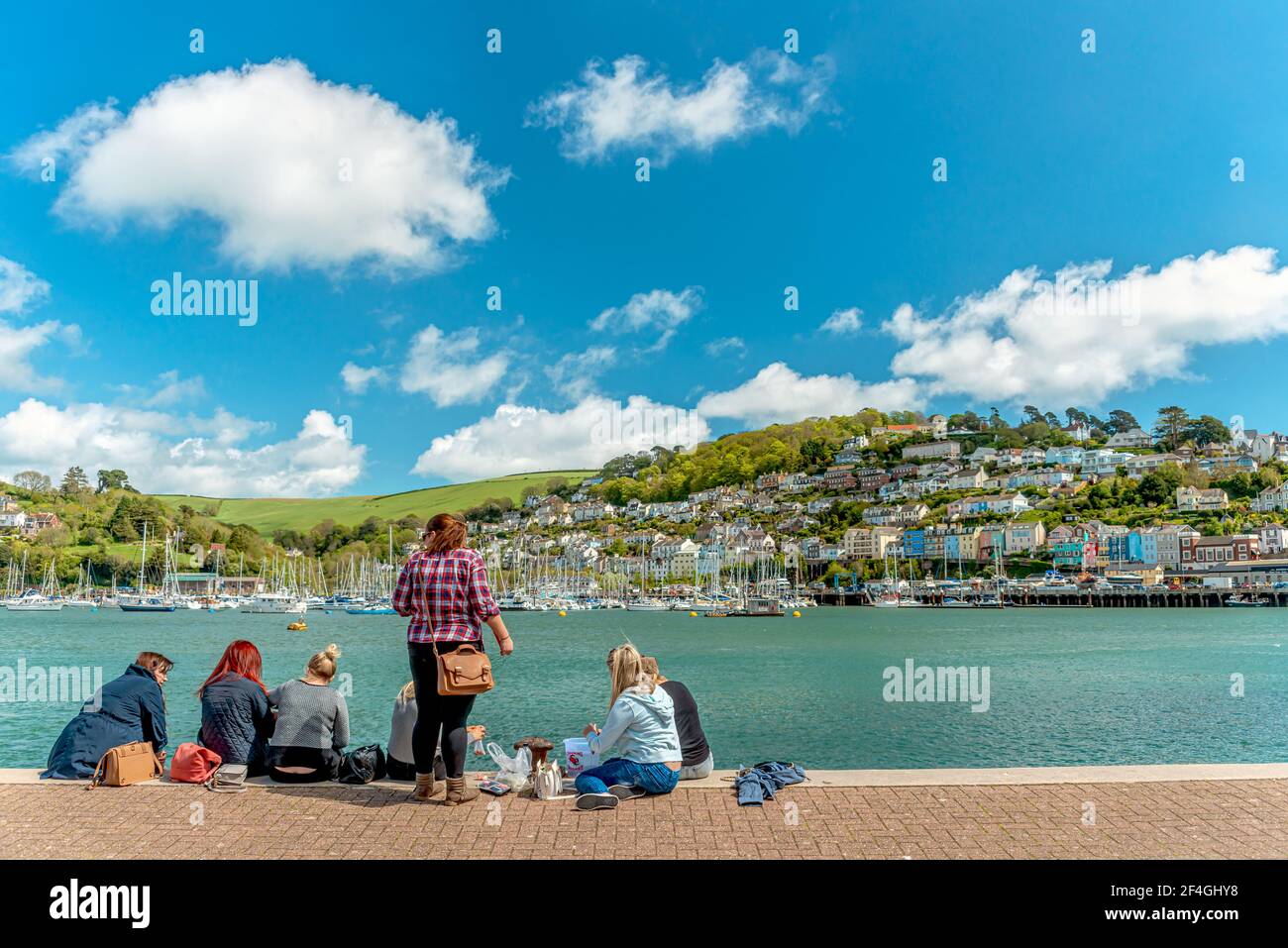 Ragazze che si divertono con un picnic sul lungomare del porto di Dartmouth, Devon, Inghilterra, Regno Unito Foto Stock