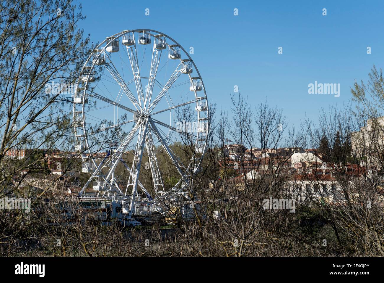 Zamora, Spagna. Marzo 20,2021. Ruota panoramica bianca con il cielo blu sullo sfondo durante la Fiera di Pasqua delle attrazioni. Foto Stock