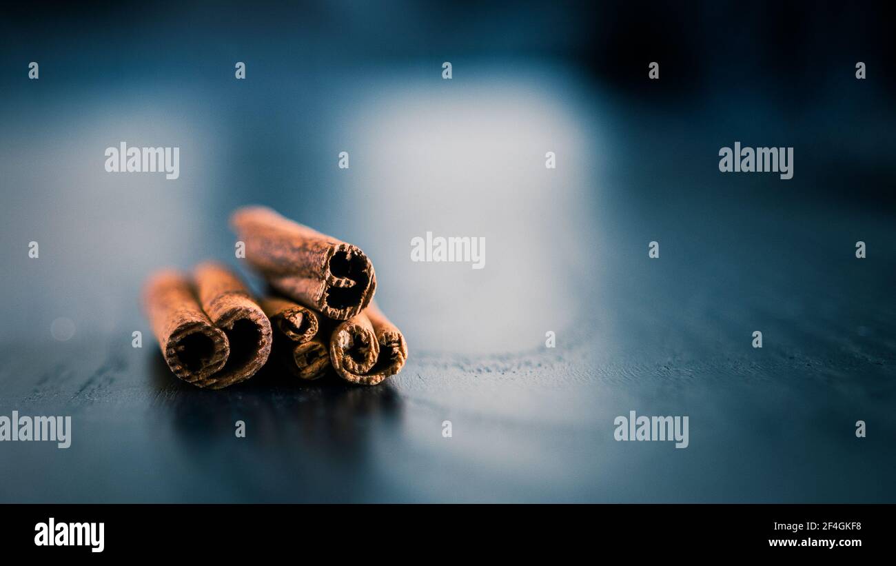 cinnamomum verum su supporto in legno blu e grigio con alcuni riflessione della luce Foto Stock