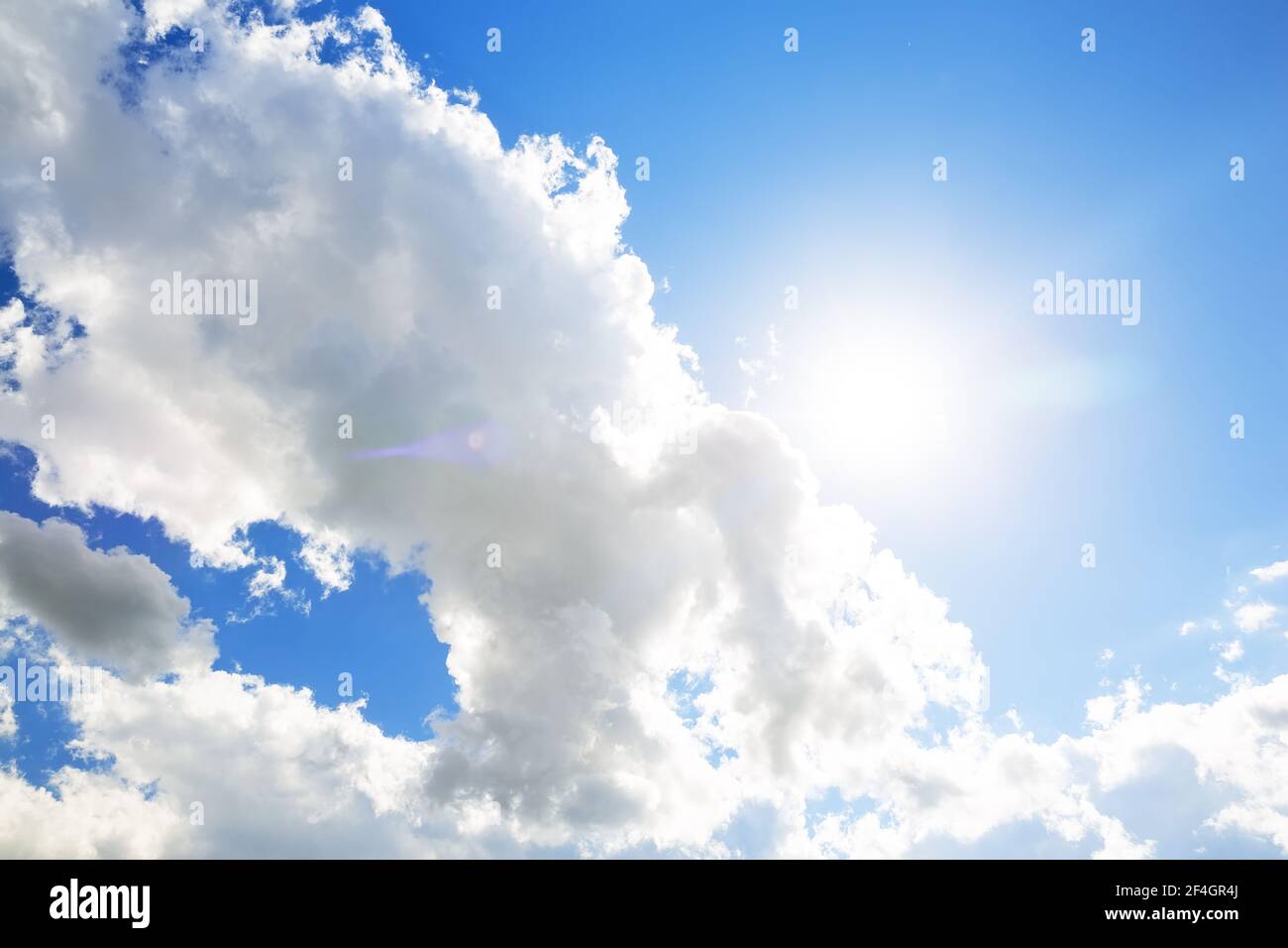 Sole con nuvole bianche e sfondo blu del cielo. Nuvole nel cielo blu. Il luminoso sole di mezzogiorno illumina lo spazio. Foto Stock