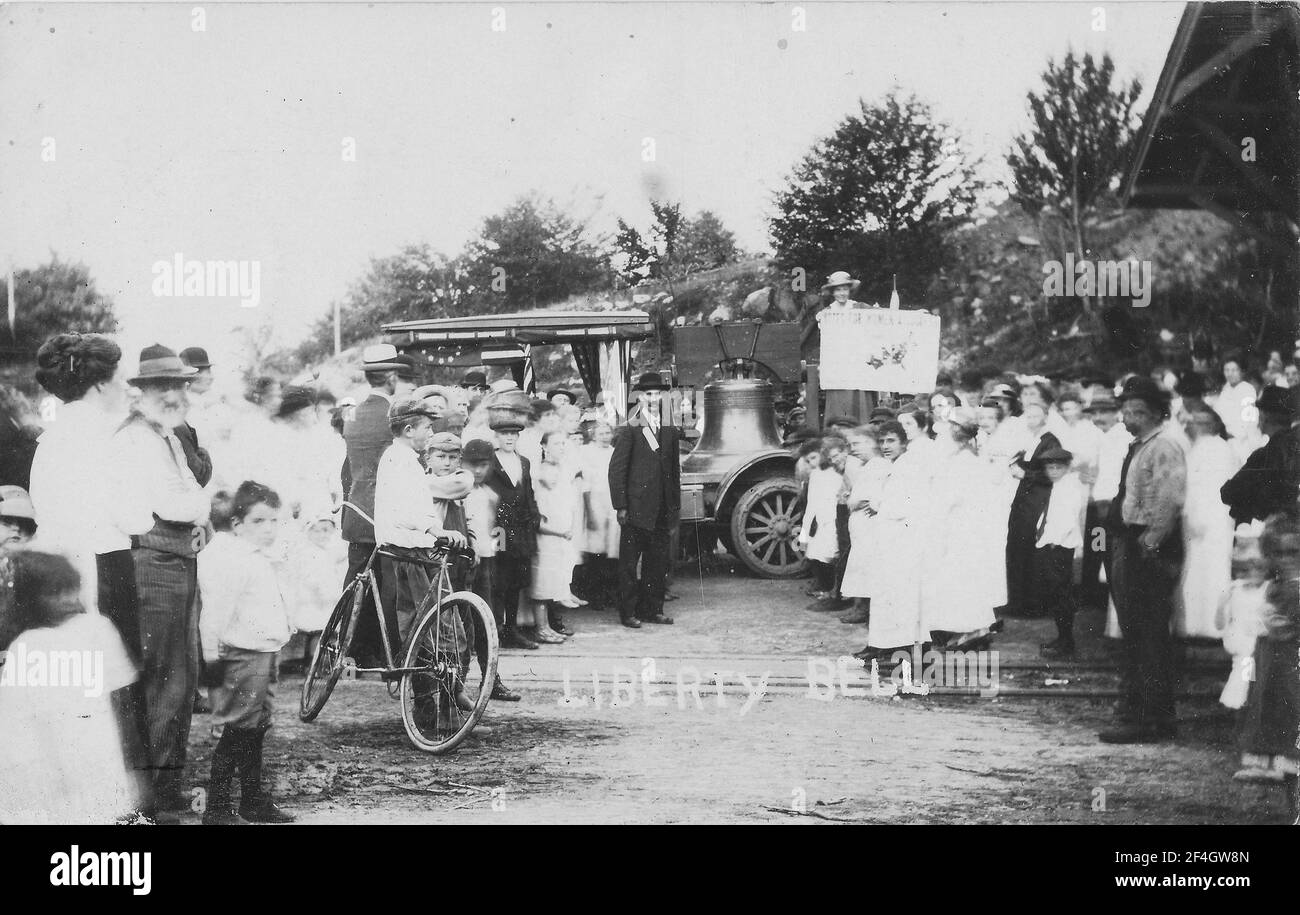 Una folla parted rivela una donna che tiene il materiale promozionale mentre si sta accanto alla Campana di Giustizia, una replica del 1915 della Campana di libertà di suffragisti Pennsylvanian, montato su un camion e utilizzato per la campagna tra il 1915 e il 1920, Pennsylvania, 1915. () Foto Stock