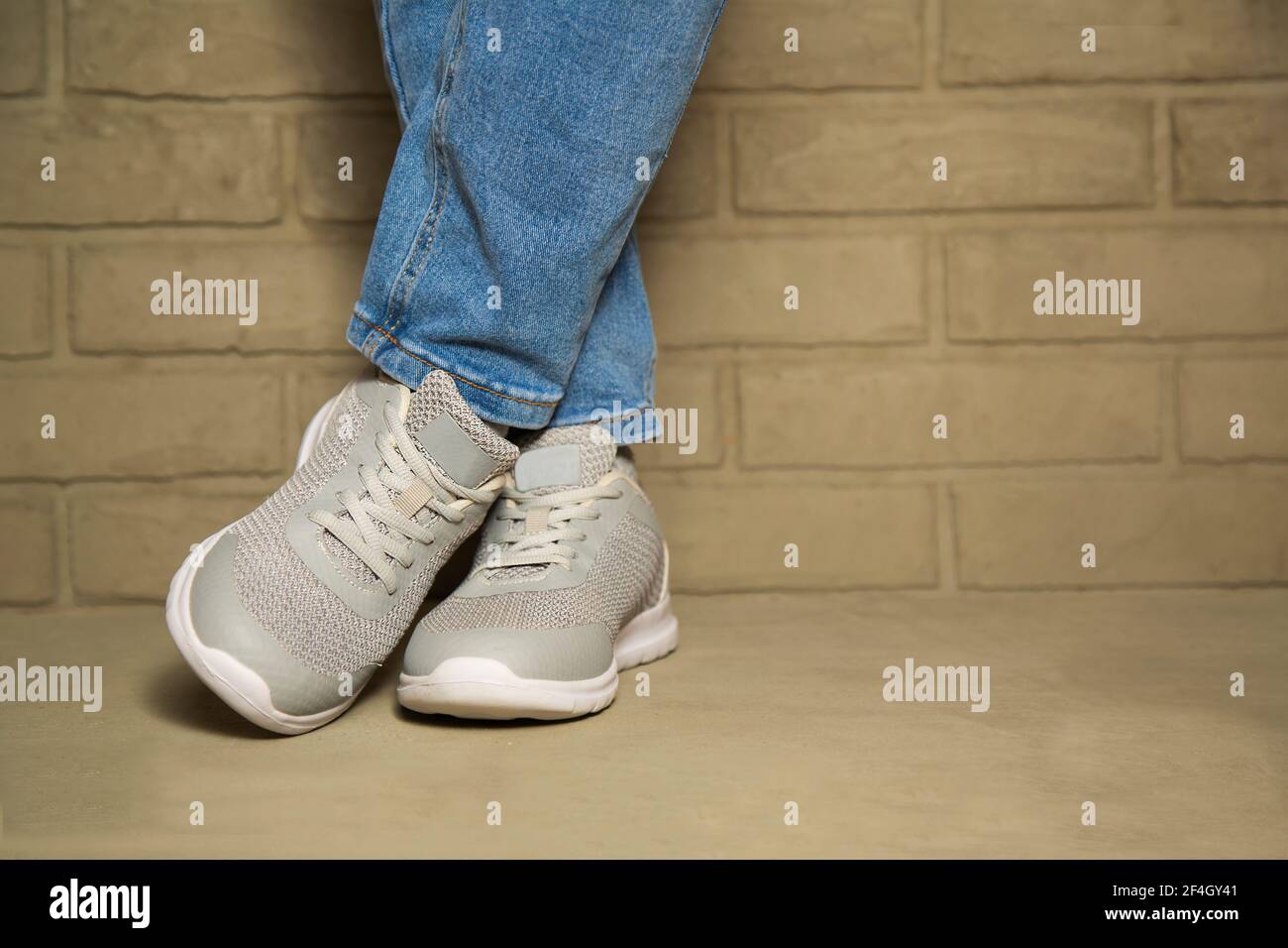 Donna che indossa abiti casual e sneakers bianche che pende in città. Moda  e concetto alla moda. Gambe femminili con scarpe sportive. Spazio di copia  Foto stock - Alamy