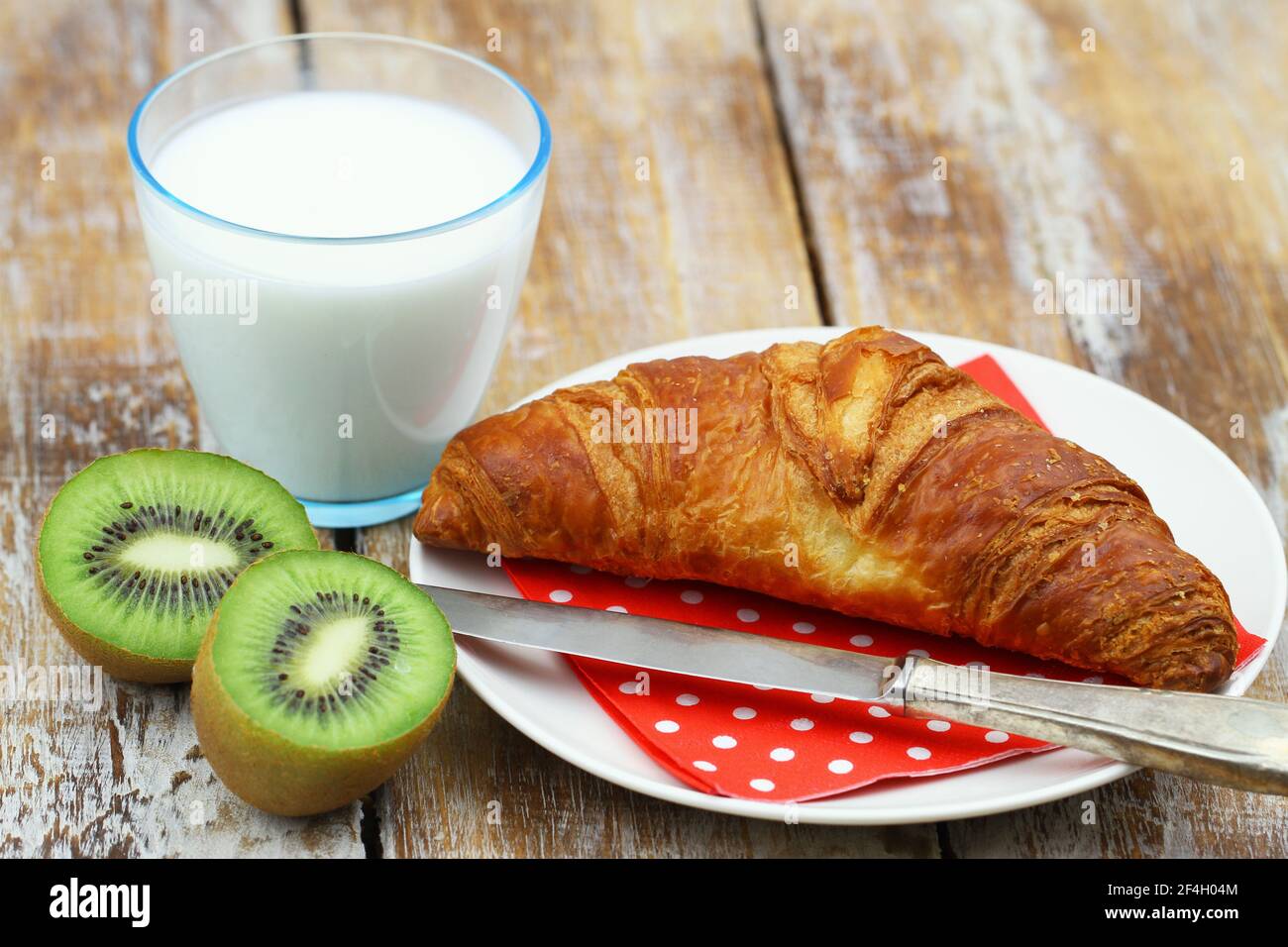 Colazione continentale semplice: Croissant francese, kiwi frutta e un bicchiere di latte Foto Stock