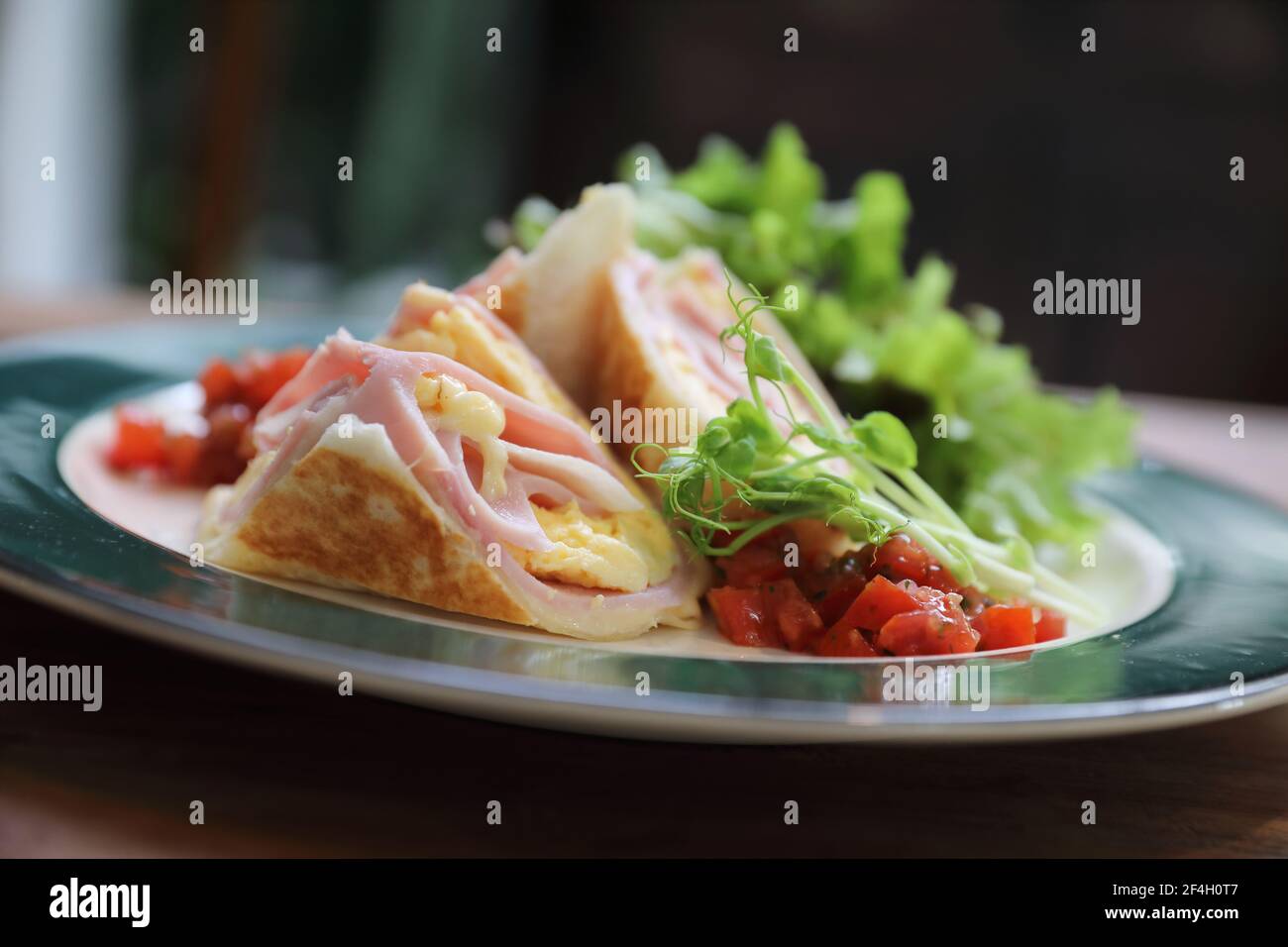 Colazione burritos prosciutto e uova con insalata in stile vintage Foto Stock