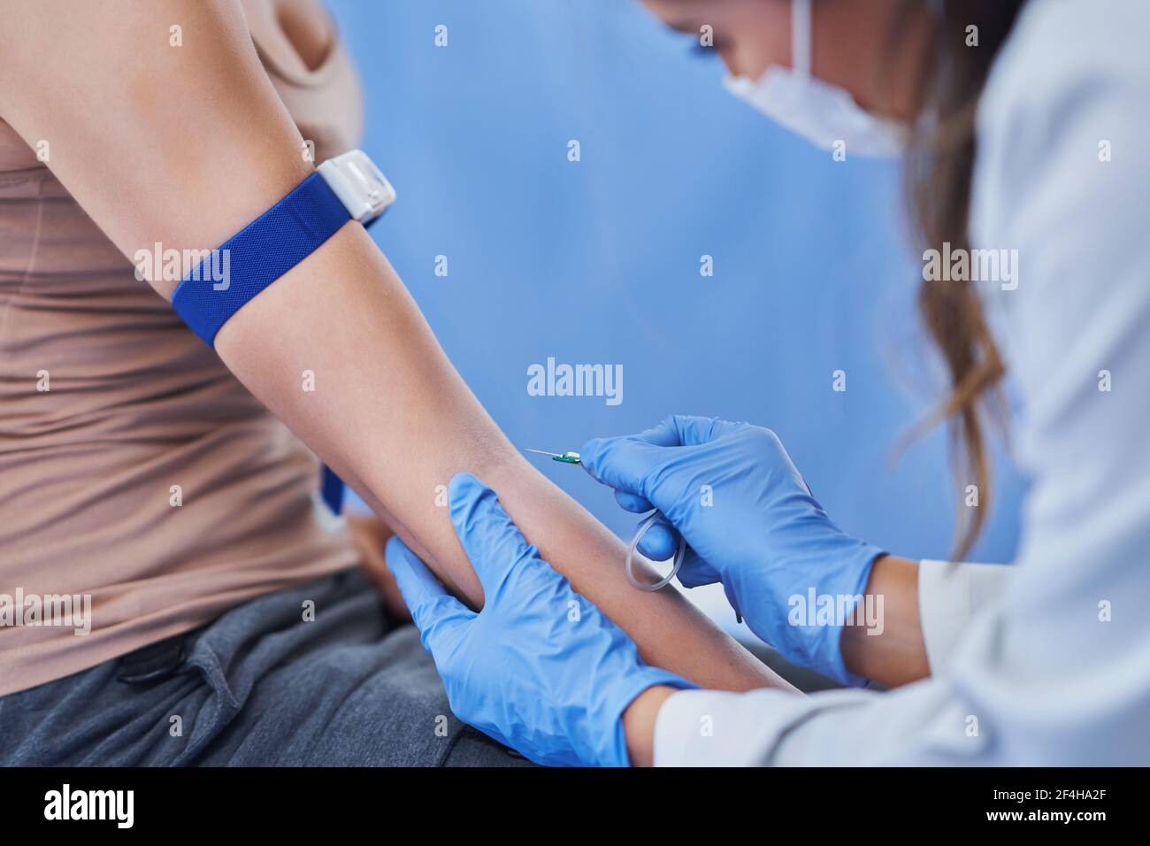 Paziente di sesso femminile con prelievo di sangue in laboratorio Foto Stock