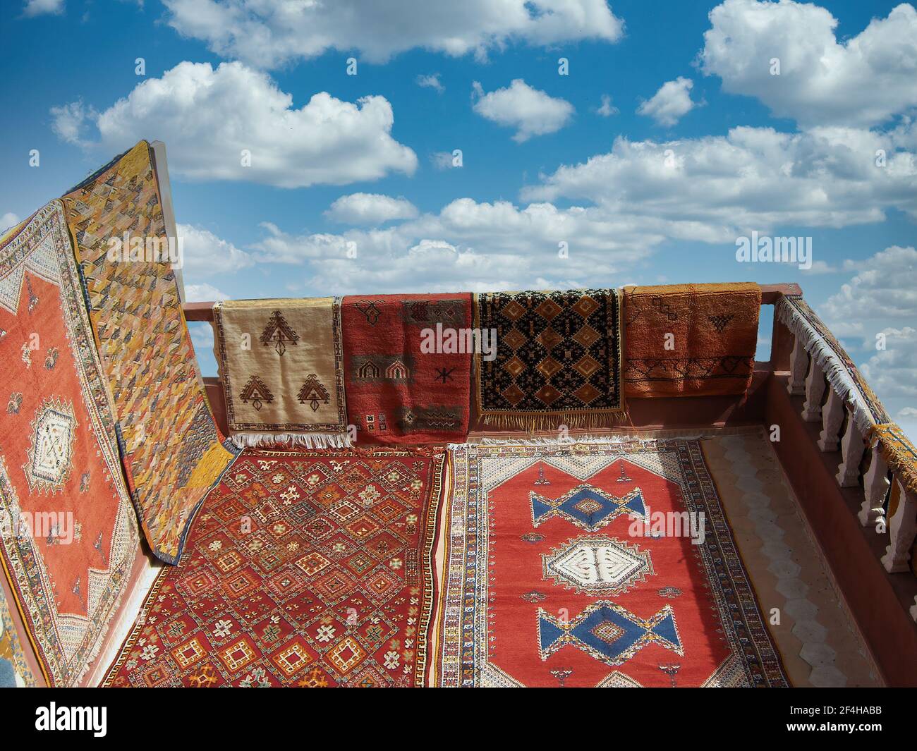 Mostra di preziosi tappeti arabi su una terrazza con un sfondo di nuvole Foto Stock