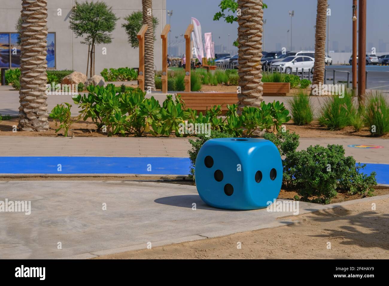 Grande sedia a forma di dadi blu nel parco giochi. Blu enorme cubo da gioco d'azzardo come una decisione creativa per i mobili urbani. Foto Stock