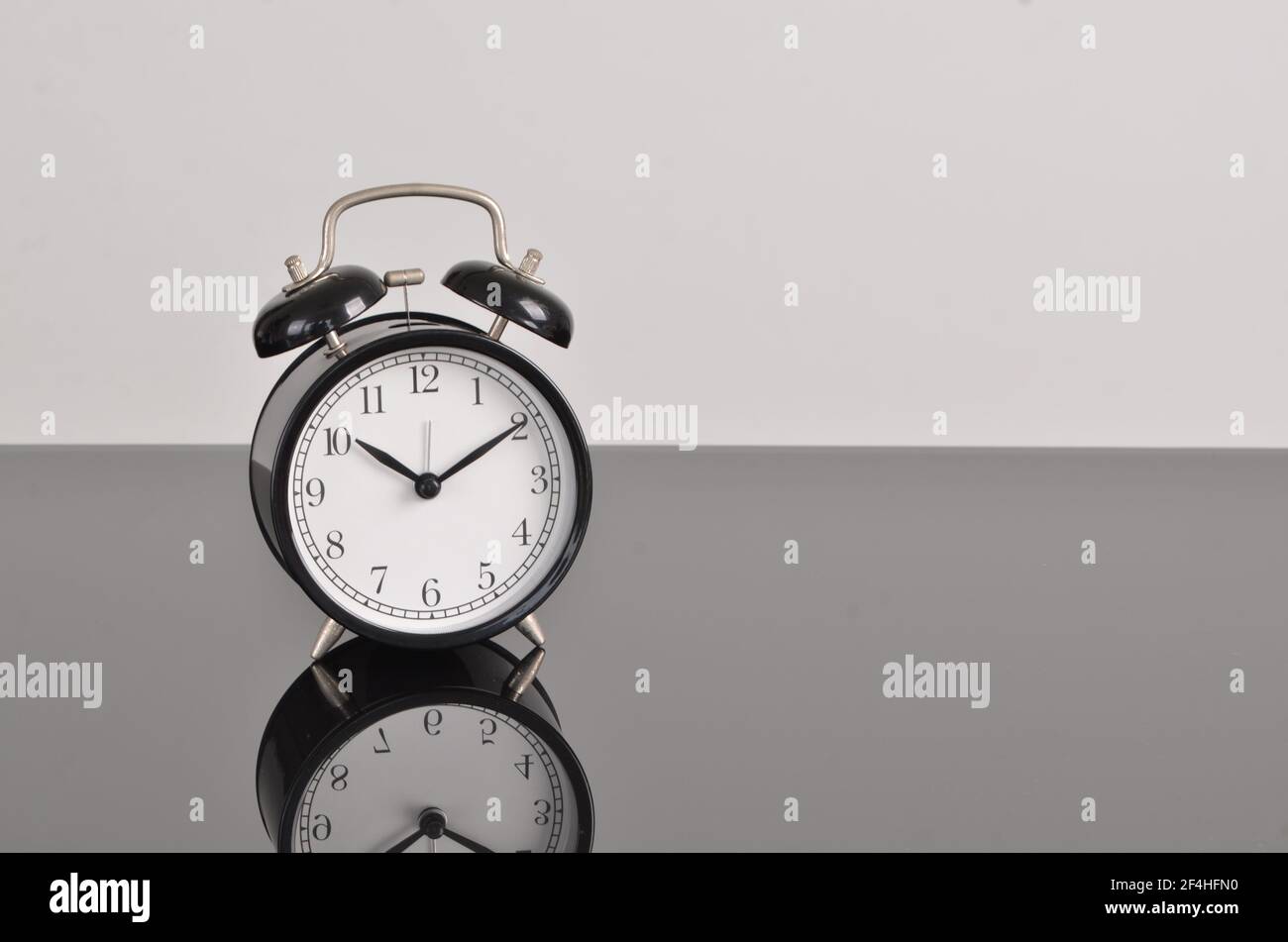 Sveglia singola su sfondo grigio. Punti di messa a fuoco selettivi Foto Stock