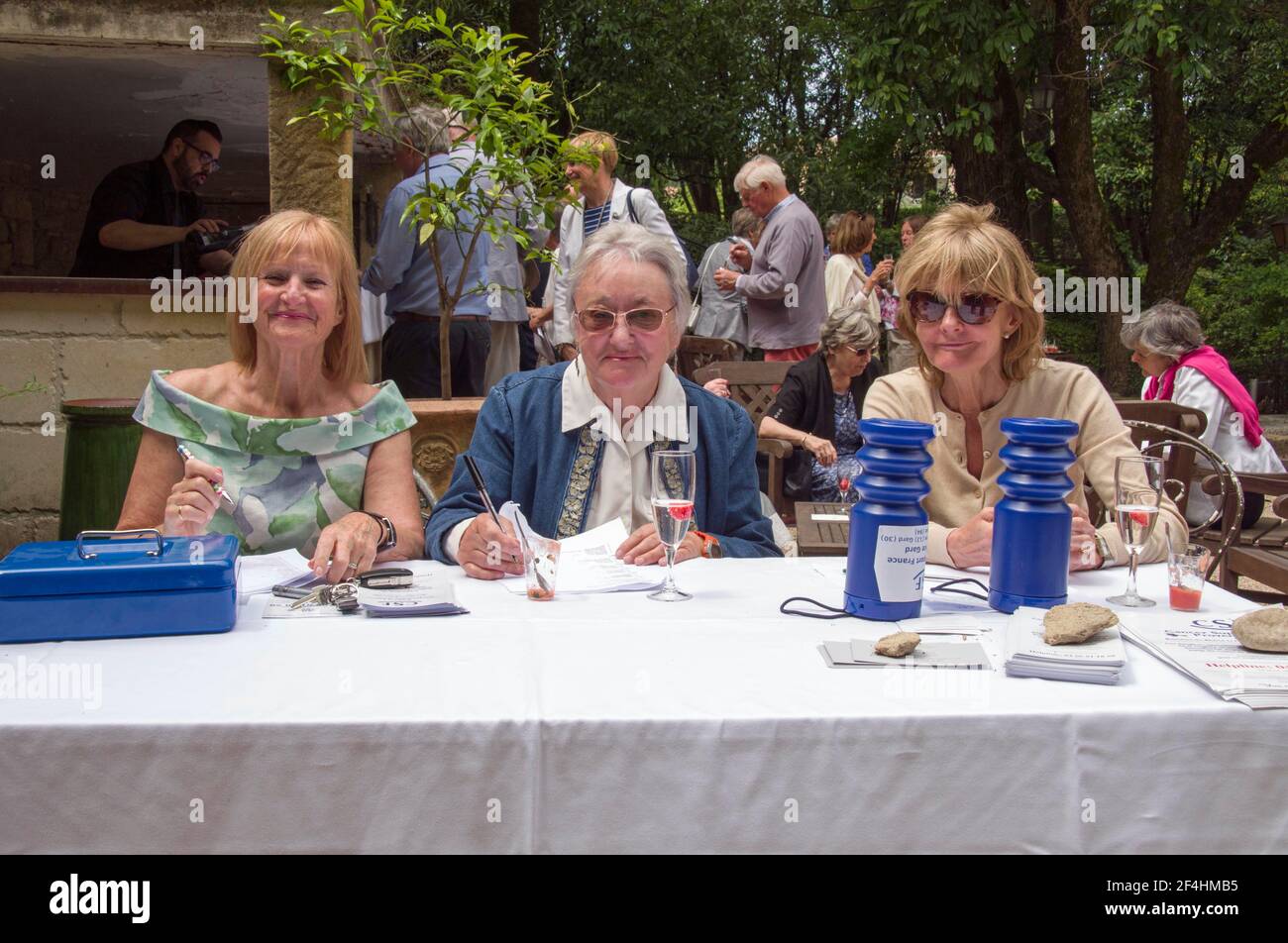 Tre donne prenotano in ospiti ad un pranzo di beneficenza per l'organizzazione britannica Cancer Support France a Uzès, Gard, Francia. Foto Stock