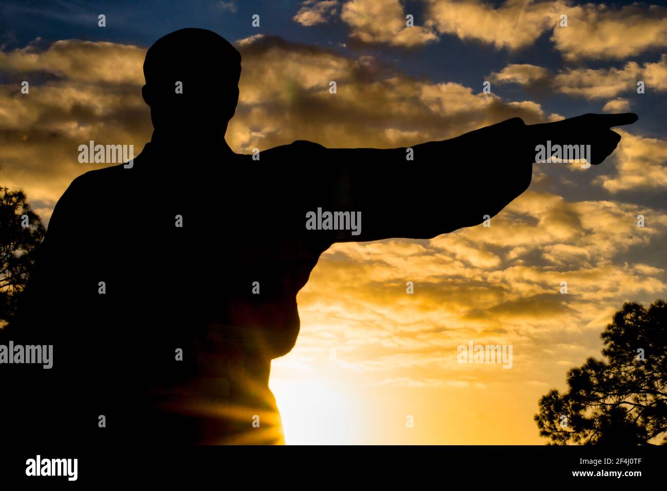 La mano di guerriero puntante del cartello d'ingresso si staglia contro il cielo del tramonto al Seminole Tribe of Florida's Billie Swamp Safari. Foto Stock