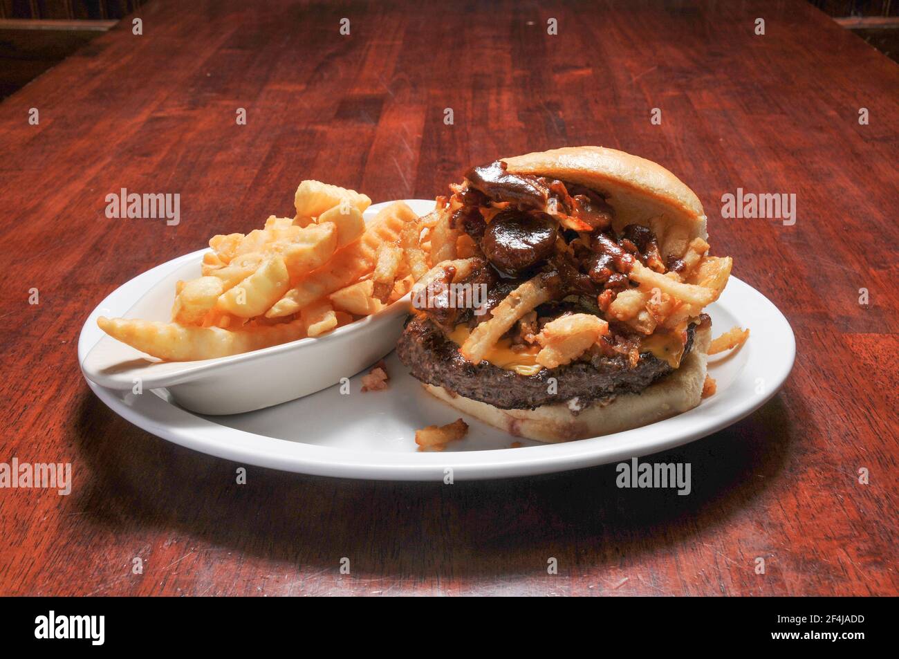 Delizioso cheeseburger con tutti i fissaggi su un panino Foto Stock