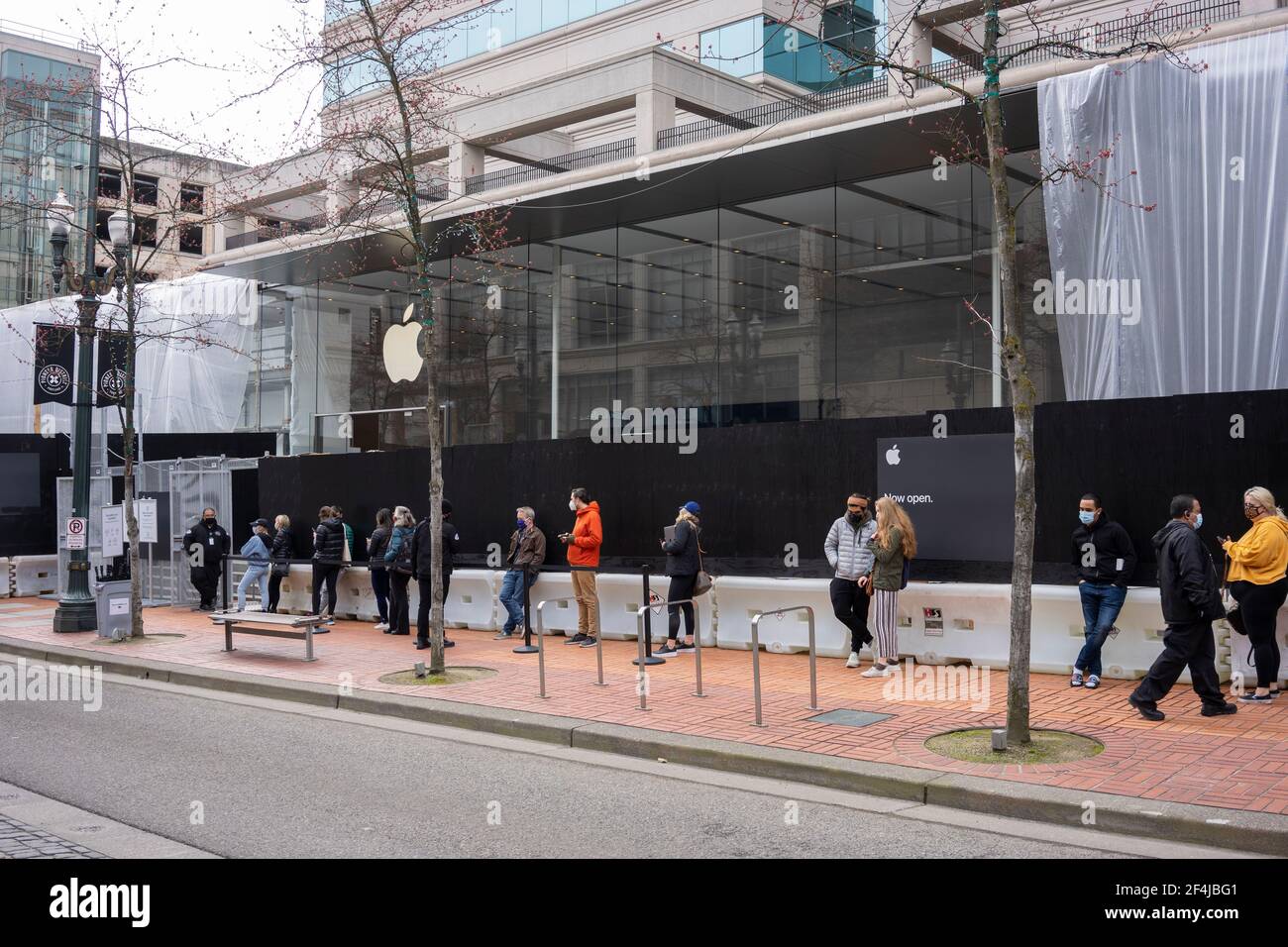 Gli acquirenti mascherati che avevano effettuato prenotazioni online si sono piazzati domenica 21 marzo 2021, al di fuori dell'Apple Store Pioneer Place, riaperto il 22 febbraio... Foto Stock
