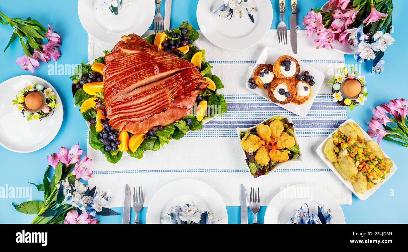 Tavolo di Pasqua festivo con prosciutto, insalata e frittelle. Foto Stock