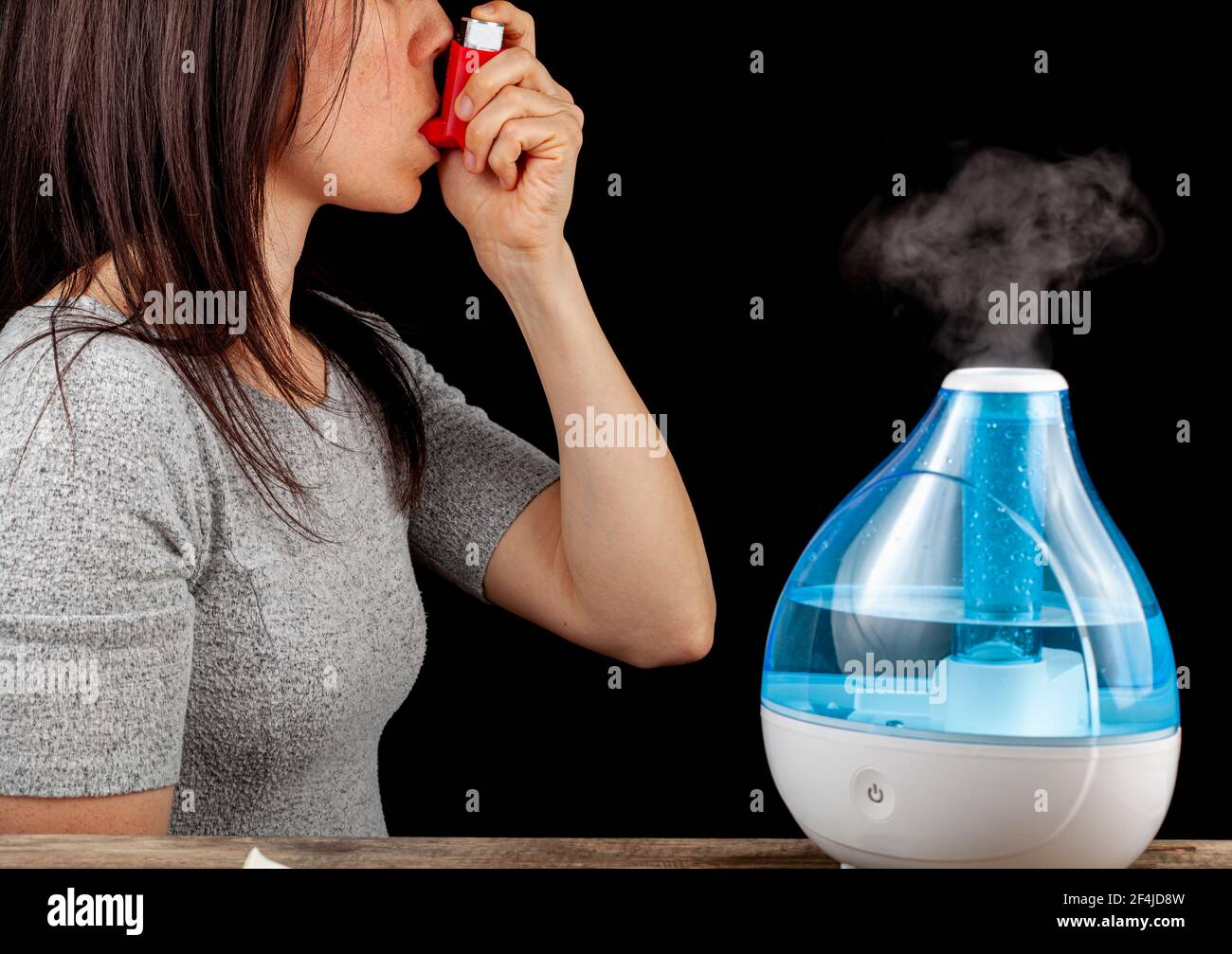 Asma, concetto di attacco allergico con umidificatore ad aria ultrasonica  che crea nebbia fredda e una donna che tiene un inalatore per somministrare  broncodilatatore o steroi Foto stock - Alamy