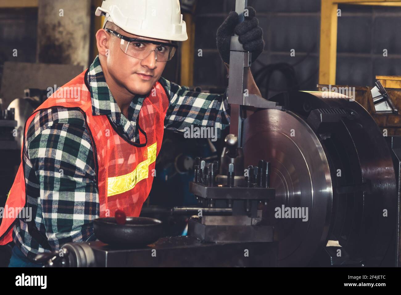 Un lavoratore o un tecnico di fabbrica intelligente esegue il lavoro della macchina in un'officina di produzione . Concetto di industria e ingegneria . Foto Stock