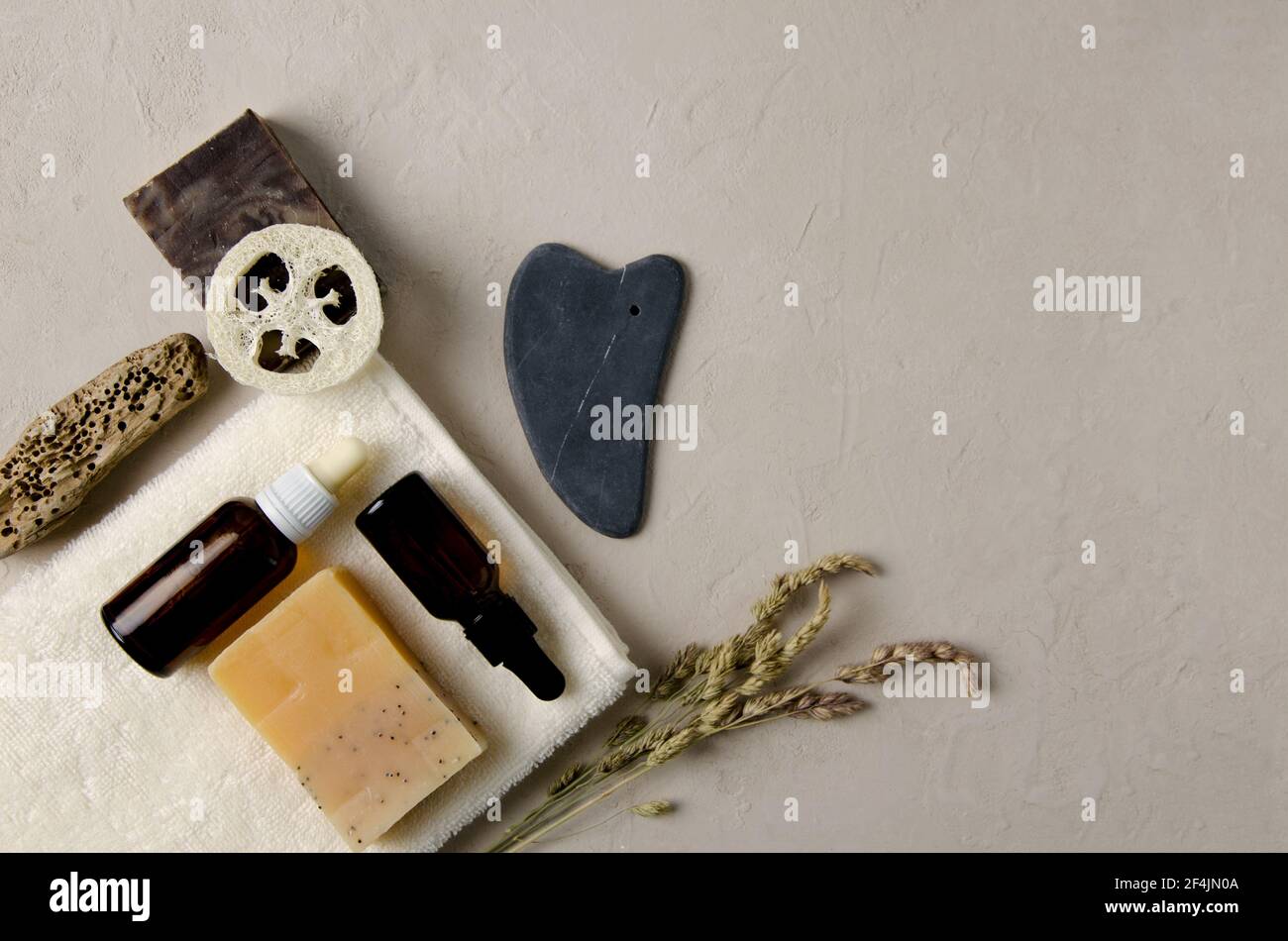 Accessori cosmetici per la cura del corpo, della mano, del viso. Sulla salvietta è presente sapone naturale, siero naturale in bottiglie di vetro con una pipetta, gouache naturale sto Foto Stock