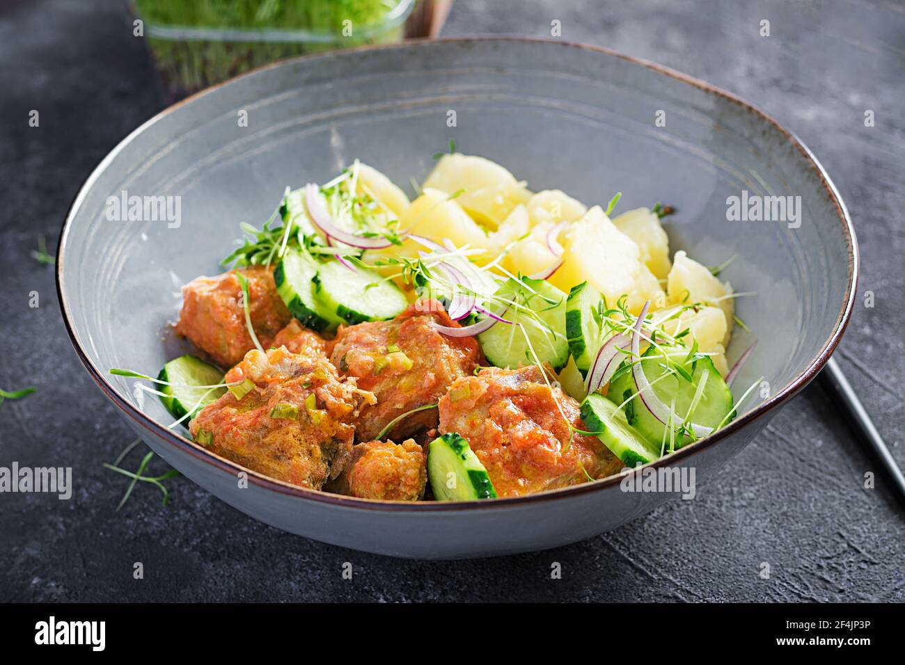 Filetto di pesce al vapore con salsa di pomodori, patate bollite e insalata di cetrioli freschi. Pasto dietetico. Cibo Lenten. Foto Stock
