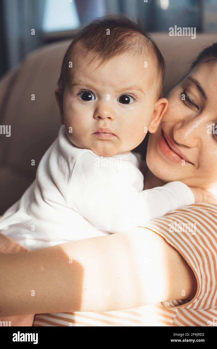 orgogliosa madre caucasica sta tenendo il suo neonato sorridente a. lui Foto Stock