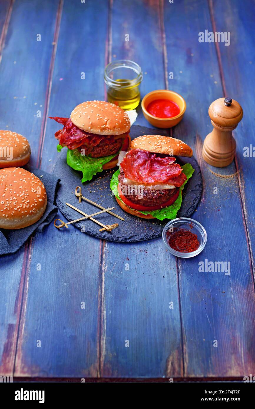 Hamburger di carne con formaggio affumicato e pancetta croccante Foto Stock