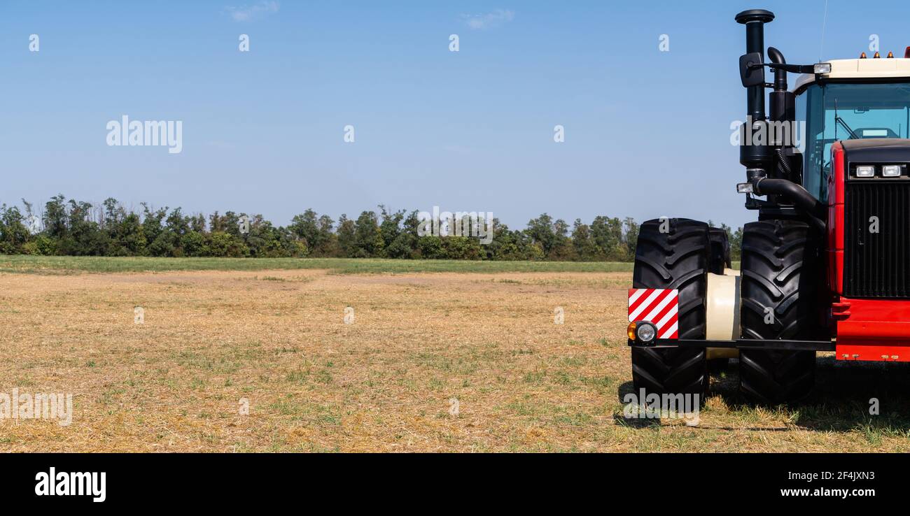 Trattore rosso su un campo agricolo Foto Stock
