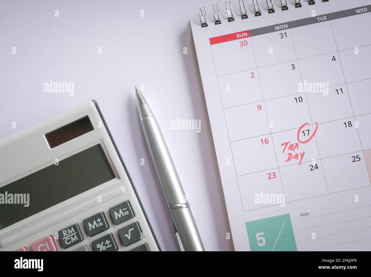 Giorno delle tasse, parole manoscritte di colore rosso sul calendario del 17 maggio. Vista dall'alto. Promemoria sulla nuova data di scadenza del deposito fiscale 2021. Foto Stock