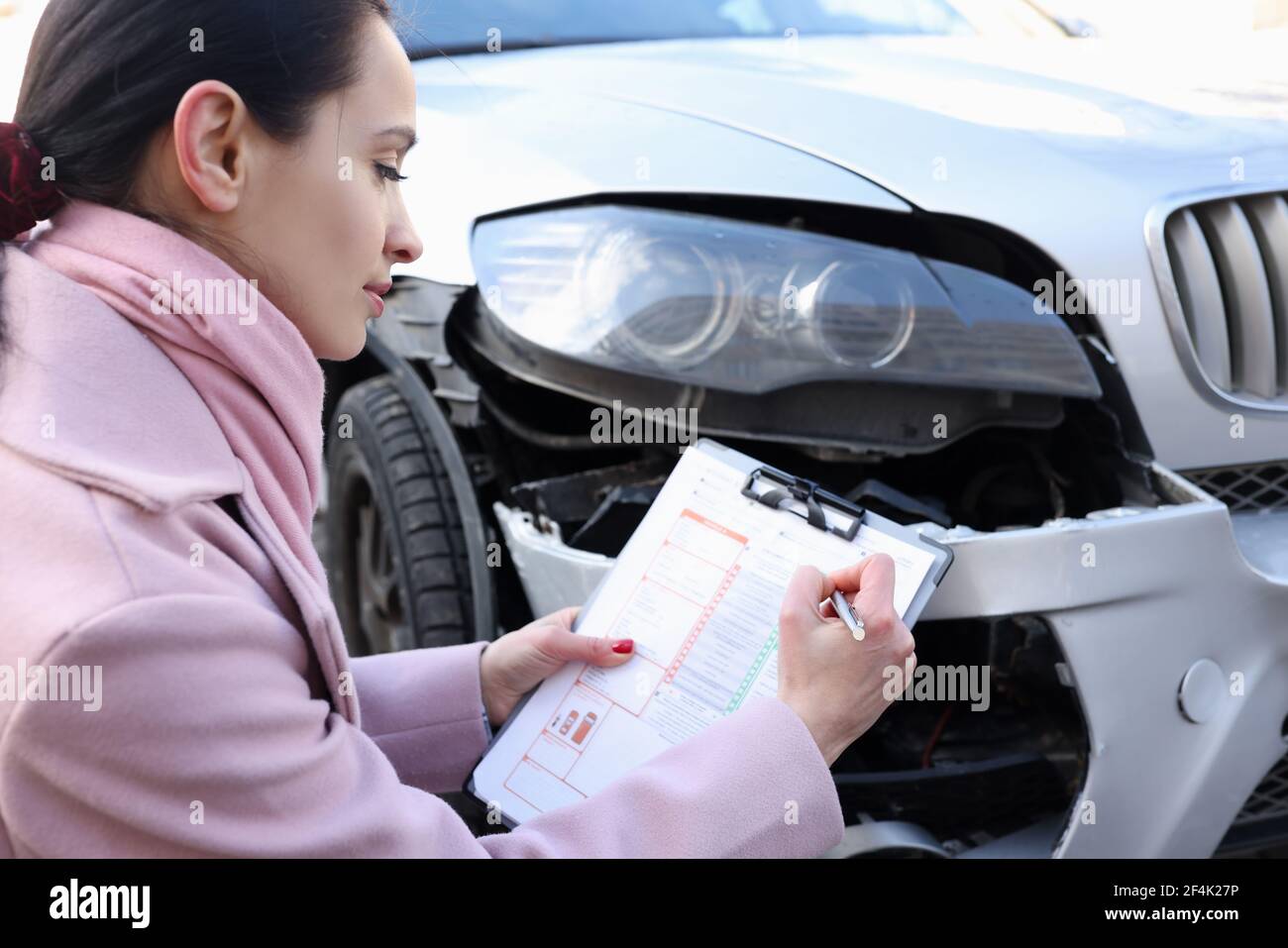 L'agente assicurativo femminile registra un caso assicurativo per incidente d'auto Foto Stock