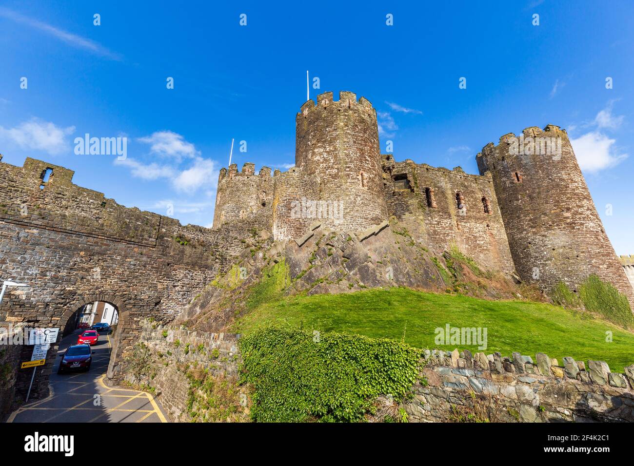 La strada cittadina attraverso le mura del castello a Conwy, Galles Foto Stock