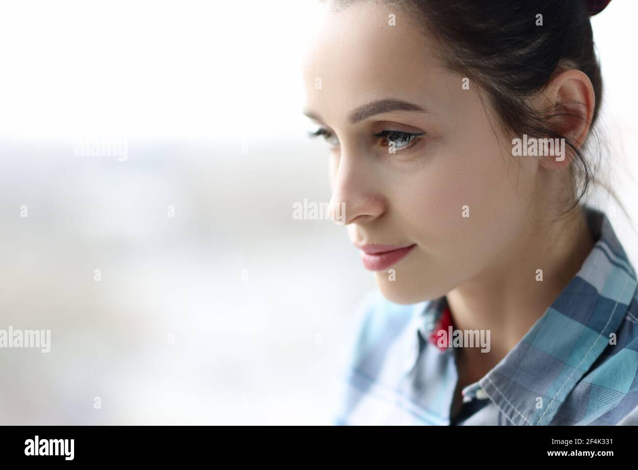 Ritratto di giovane donna sconvolto vicino alla finestra Foto Stock