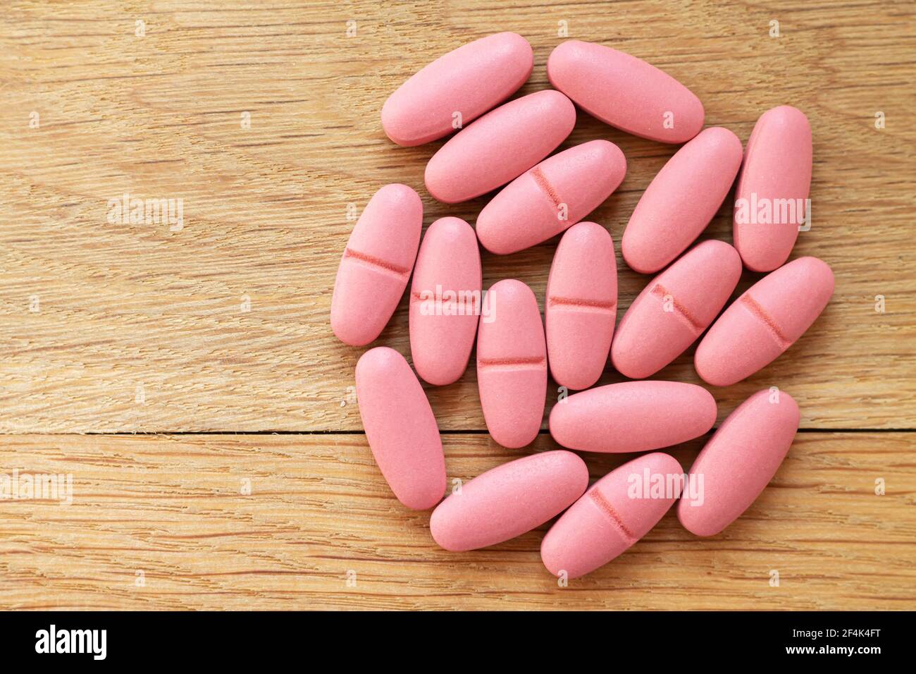 Pila di pillole rosa o vista dall'alto della droga su legno sfondo Foto  stock - Alamy