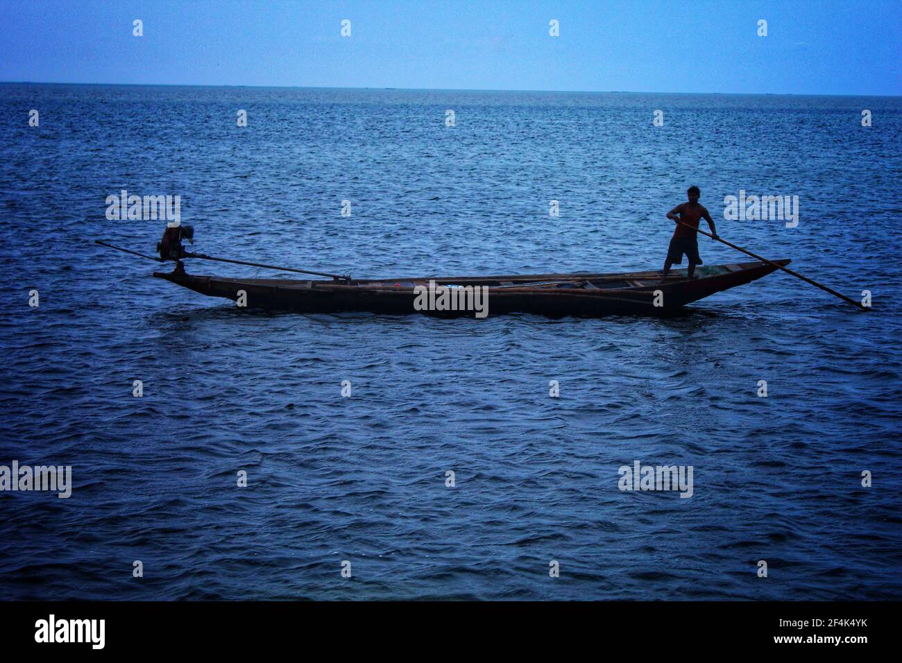 pescatore pesca con baot in serata buia nel lago di chilka Foto Stock