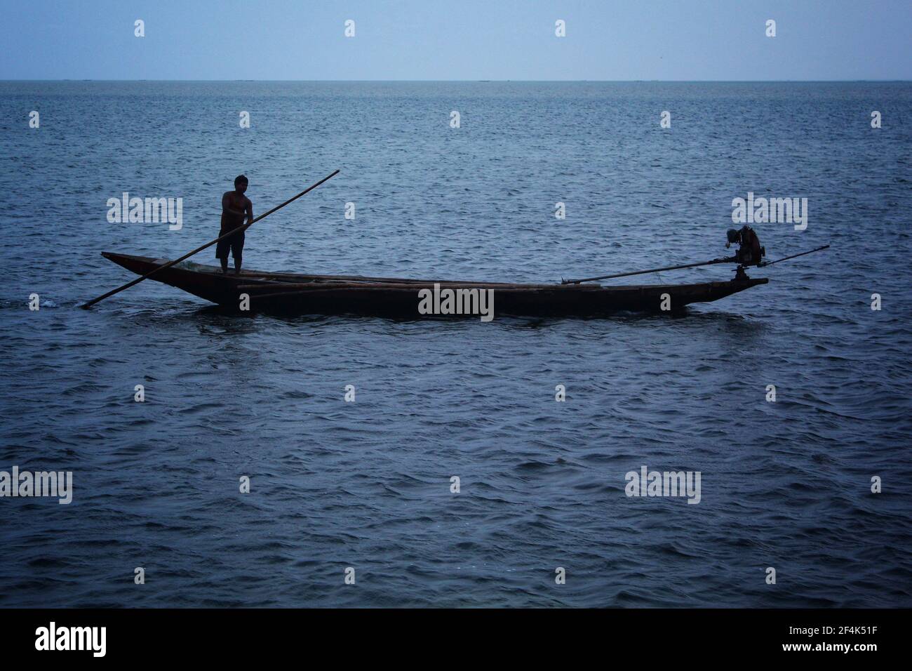 pescatore pesca con baot in serata buia nel lago di chilka Foto Stock