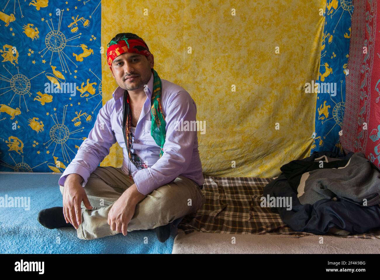 Calais, Francia. Un immigrato illegale dal Medio Oriente / Afghanistan seduto e rilassante all'interno della sua tenda di fortuna all'interno della giungla, mentre pianifica il suo trigger l'Oceano Atlantico / il Chanel verso il Regno Unito / Inghilterra. Lui e molti dei suoi colleghi rifugiati / migranti vivono in cattive condizioni all'interno della giungla, poiché le misure per impedire di viaggiare nel Regno Unito, rendono una transizione sempre più difficile. Foto Stock