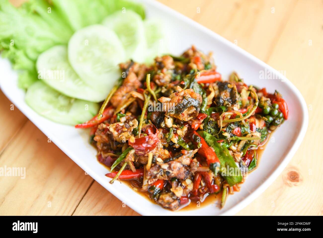 rana di carne tritata puff caldo e piccante con spezie alle erbe Sul piatto - Stir frog fritto e peperoncino rosso curry Foto Stock