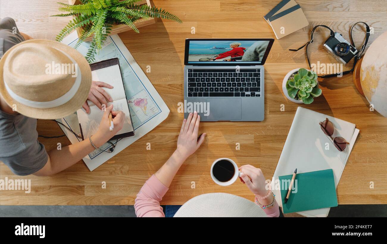 Vista dall'alto di una giovane coppia con un computer portatile che pianifica una vacanza in vacanza, concetto di viaggio desktop. Foto Stock