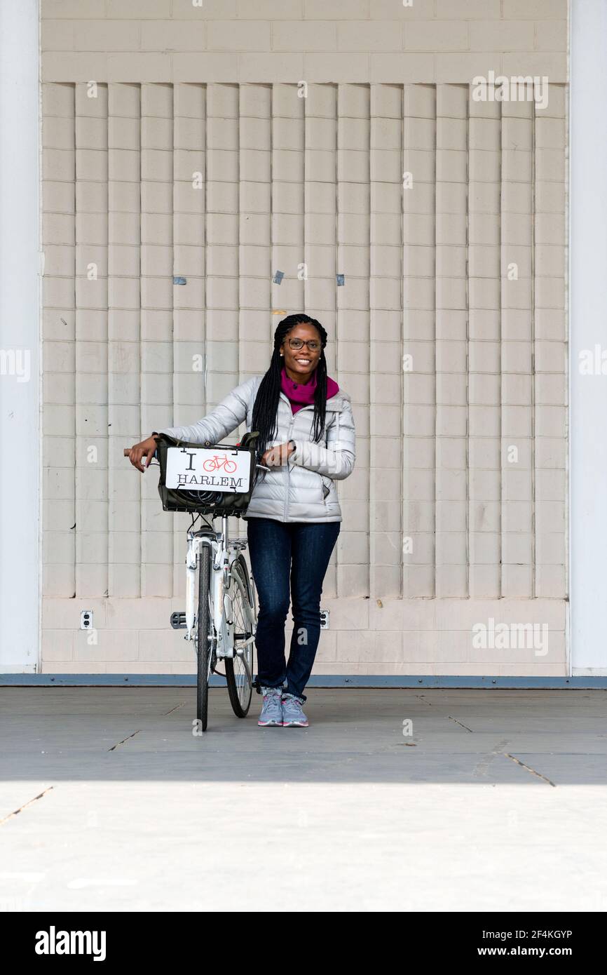 La città di New York, Stati Uniti d'America. Attraente donna afro-americana  dando un tour guidato in bicicletta attraverso Harlem, Manhattan Foto stock  - Alamy