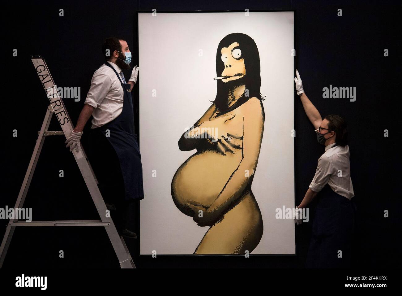Tecnici di galleria con concetto originale per Jadely Legal Poster (dopo Demi Moore) di Banksy, stimato a 2-3 milioni di sterline, a Sotheby's a Mayfair, Londra, durante un'anteprima della vendita moderna del Rinascimento, la prima grande vendita della casa d'asta del 2021. Data immagine: Lunedì 22 marzo 2021. Foto Stock