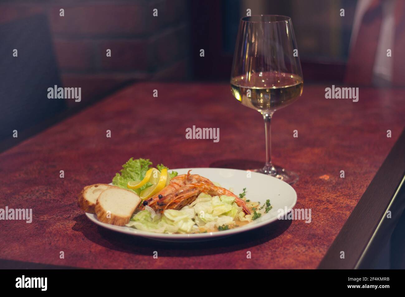 Cibo del ristorante con ingredienti freschi - gamberi giganti con freschi insalata e bicchiere di vino bianco Foto Stock