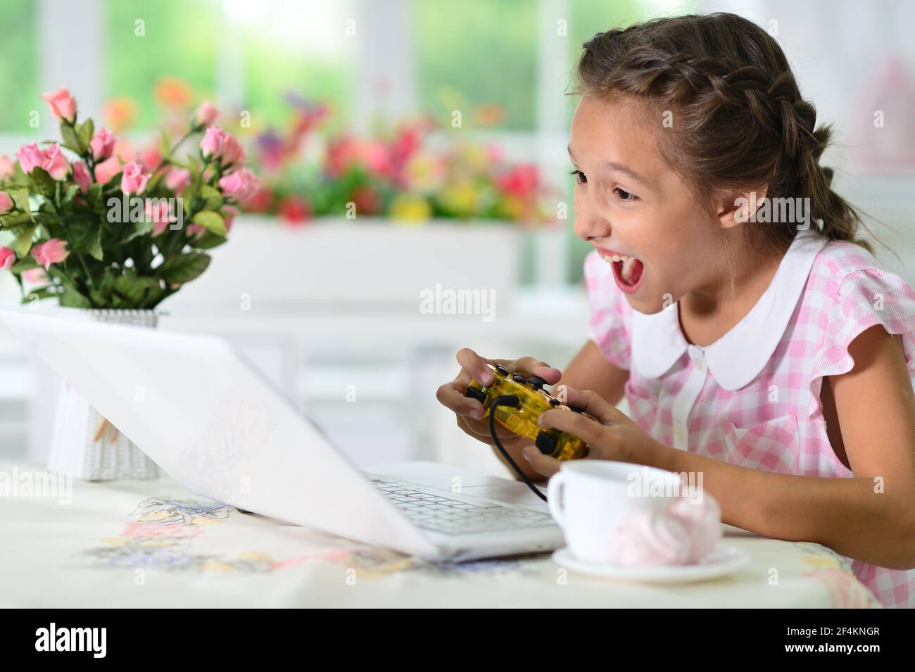 Ragazza carina emozionale utilizzando il computer portatile gioco Foto Stock