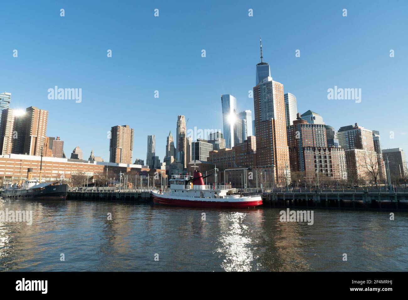 Lower Manhattan, vista dal molo 26 nell'Hudson River Park con lo storico piroscafo John J Harvey in primo piano. Foto Stock