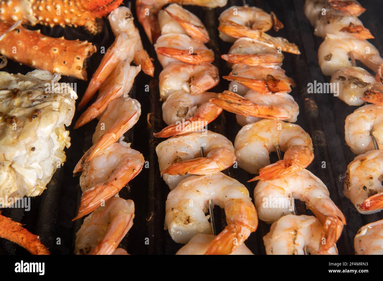 Gamberi su spiedini che cucinano su una griglia Foto Stock