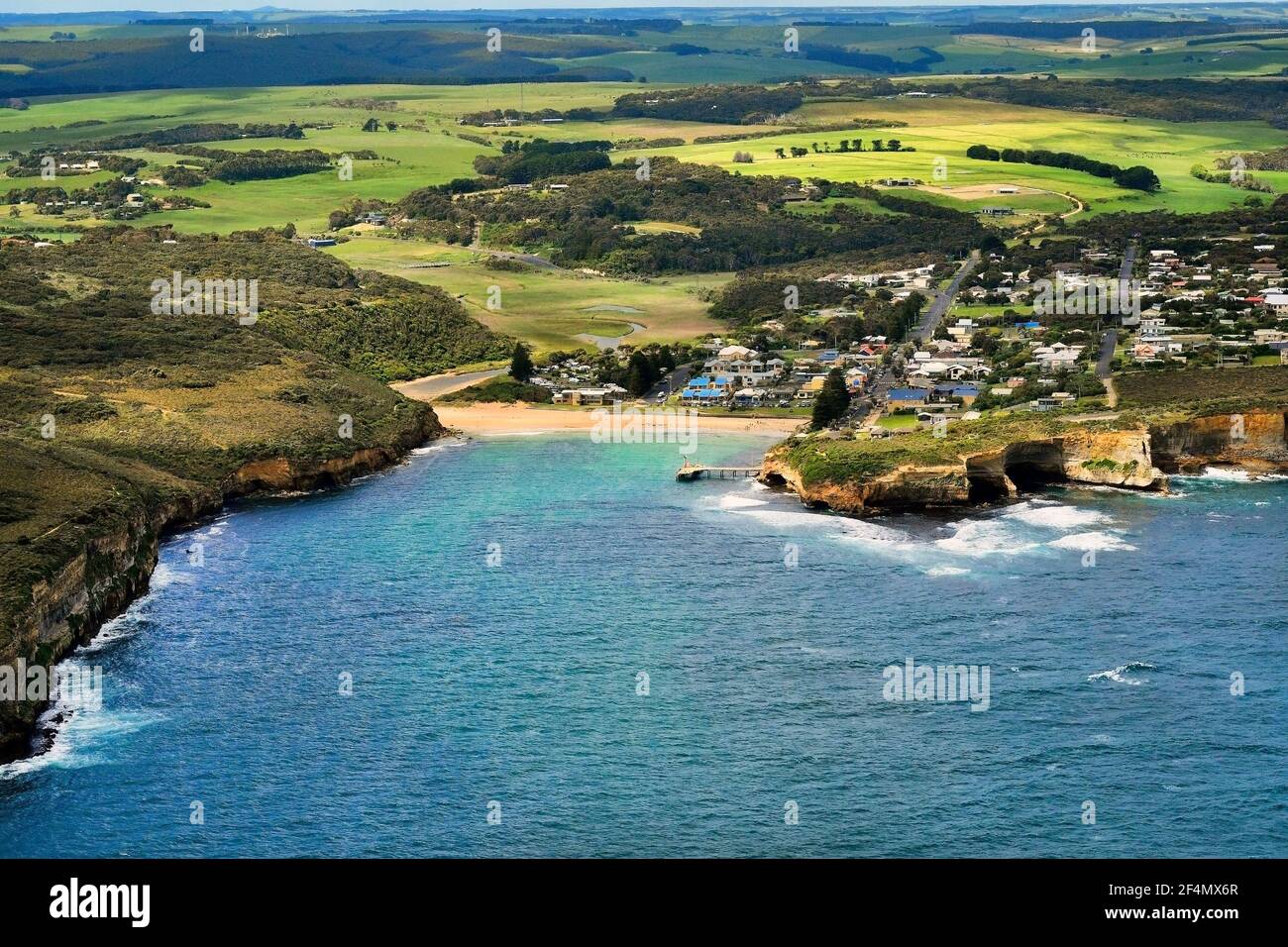 Australia, Victoria, vista aerea del villaggio di Port Campbell con spiaggia e molo nel parco nazionale di Port Campbell Foto Stock